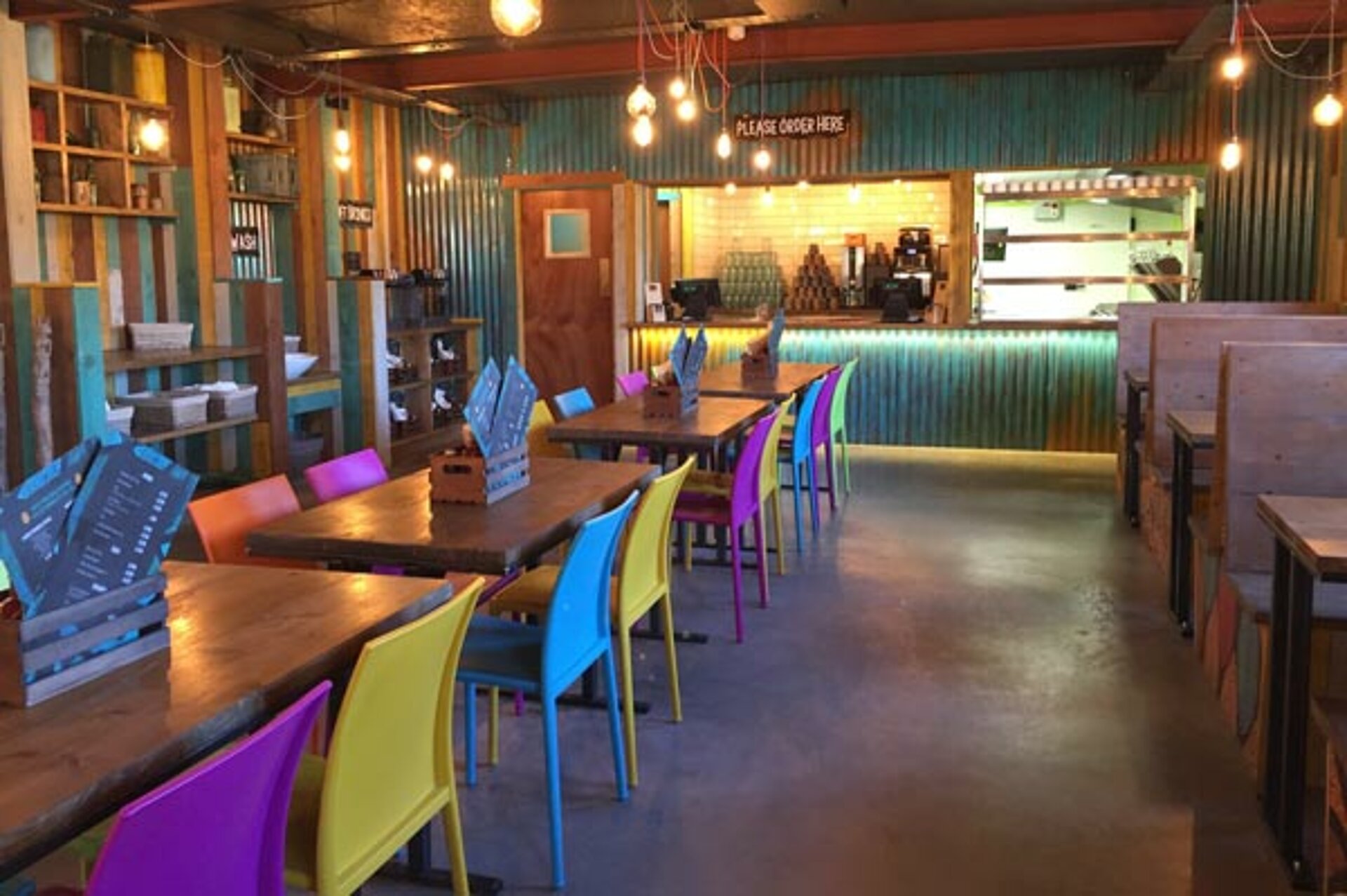 Interior of the Burger Co at West Midlands Safari Park, featuring family tables, ambient lighting, and a counter area for ordering food