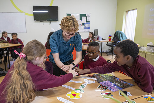 "Children with a teacher in a classroom learning about animals, engaged in an interactive and educational lesson environment