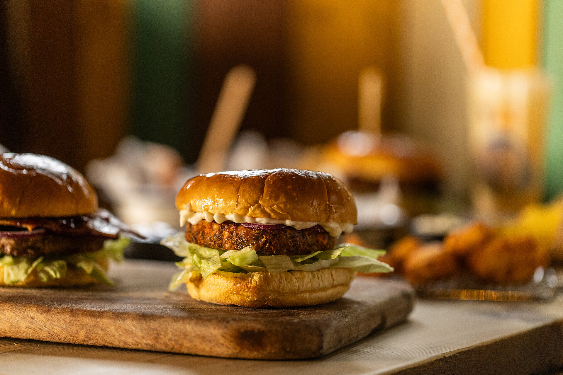 Beef burger on a plate at the Burger Co in West Midlands Safari Park, with other burgers and chicken bites visible in the background, showcasing a variety of menu options